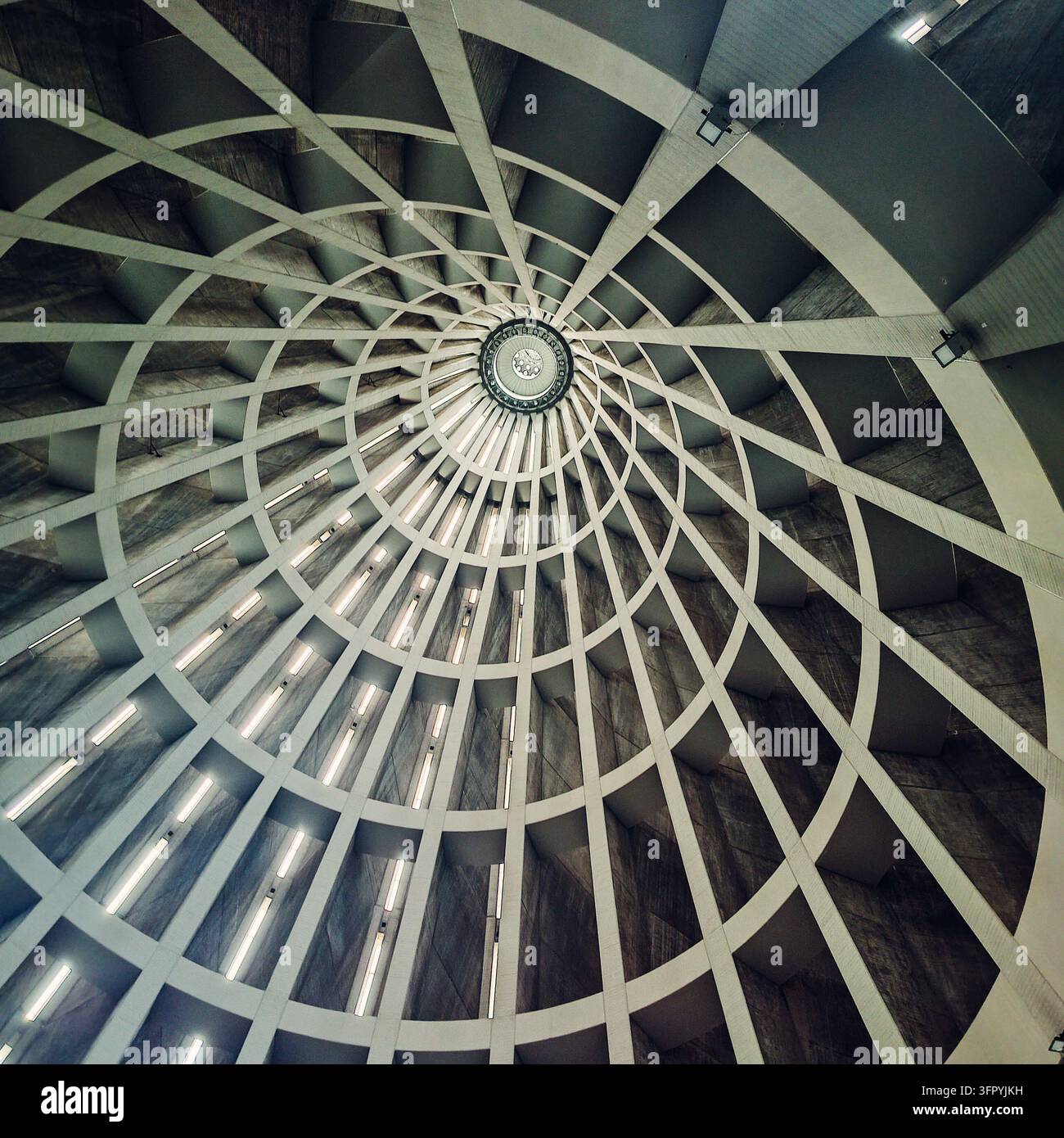 Eine nach oben gerichtete Fotografie fängt das kunstvolle und abstrakte Design einer modernen Kuppeldecke ein. Die strukturellen Elemente bilden ein radiales geometrisches Muster Stockfoto