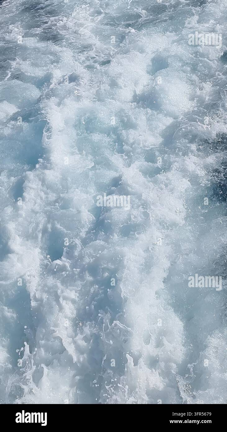 Weißer Seeschaum und türkisfarbenes Wasser als Texturhintergrund Stockfoto