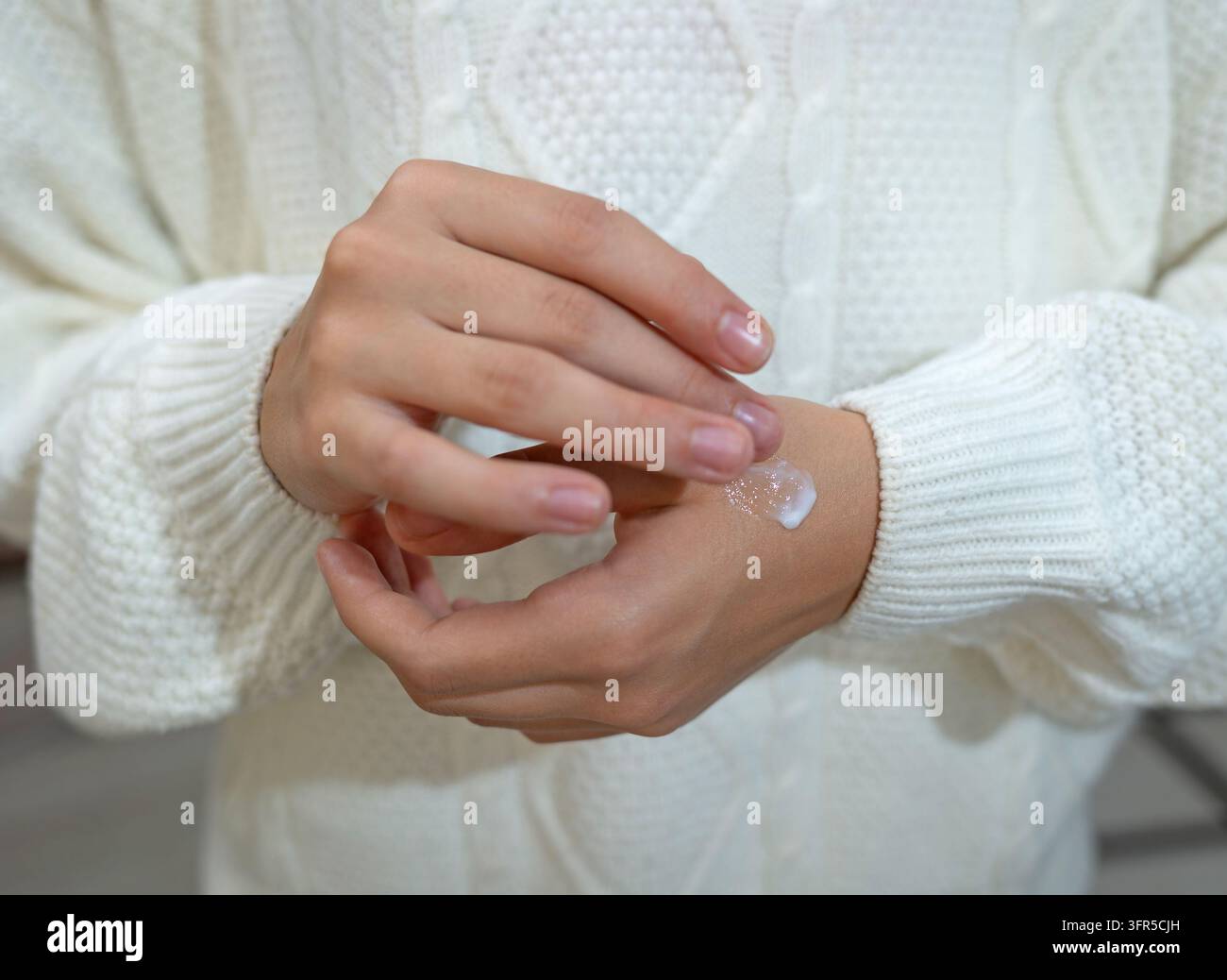 Nahaufnahme einer Frau, die feuchtigkeitsspendende Creme auf die Hand aufträgt, für die tägliche Hautpflege Stockfoto