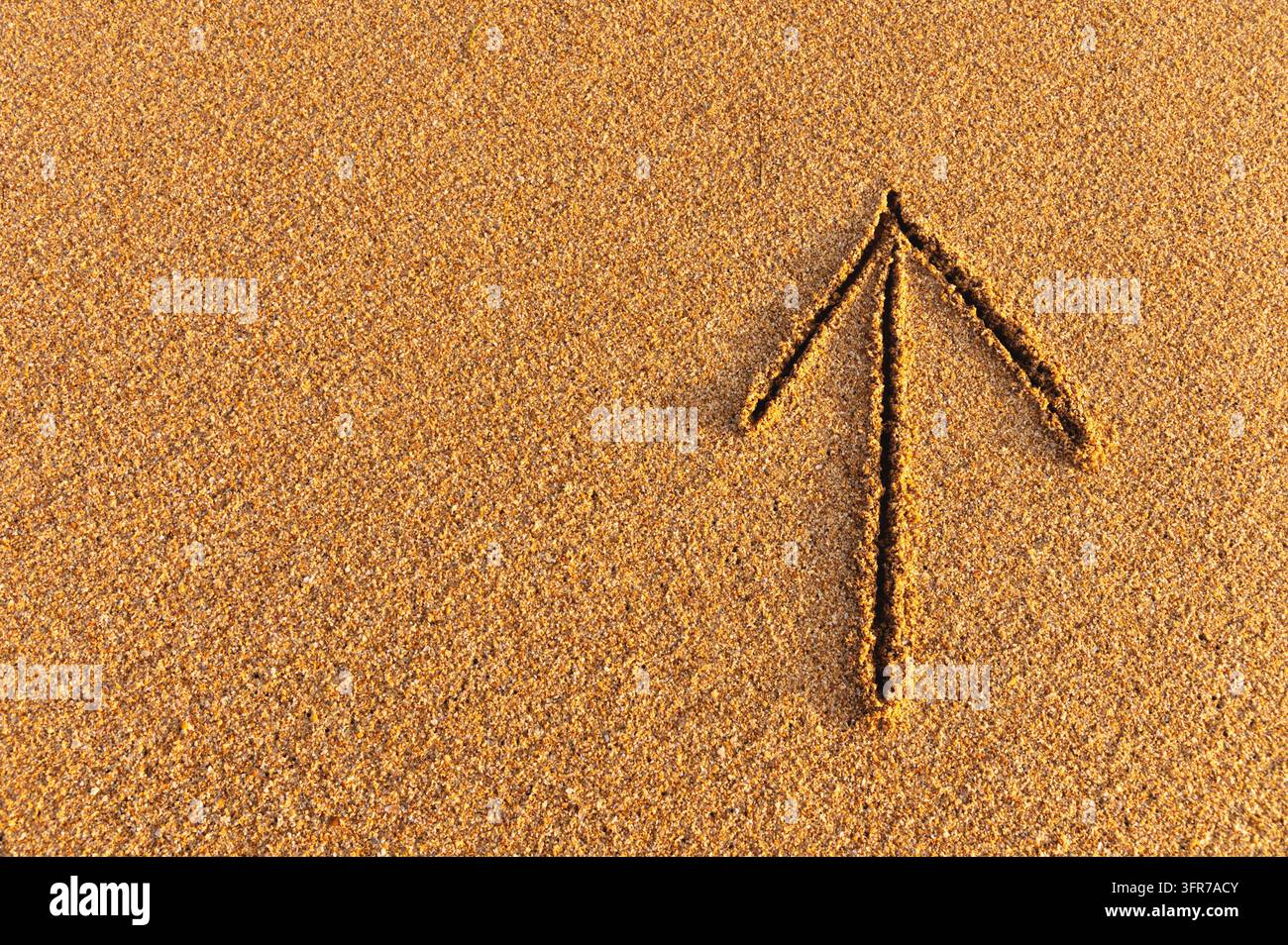 Gezeichneter Pfeil im Sand. Zeichnung eines nach oben zeigenden Pfeilschilds, Wegbeschreibung Stockfoto