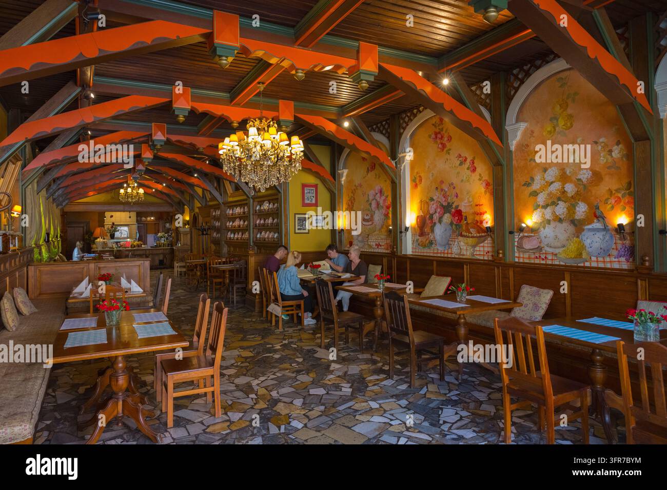 Ein gemütliches Restaurant mit Holzmöbeln, farbigen Wandgemälden und prächtigen Kronleuchtern, traditionelles polnisches Restaurant, Legnica, Liegnitz, Nieder Stockfoto