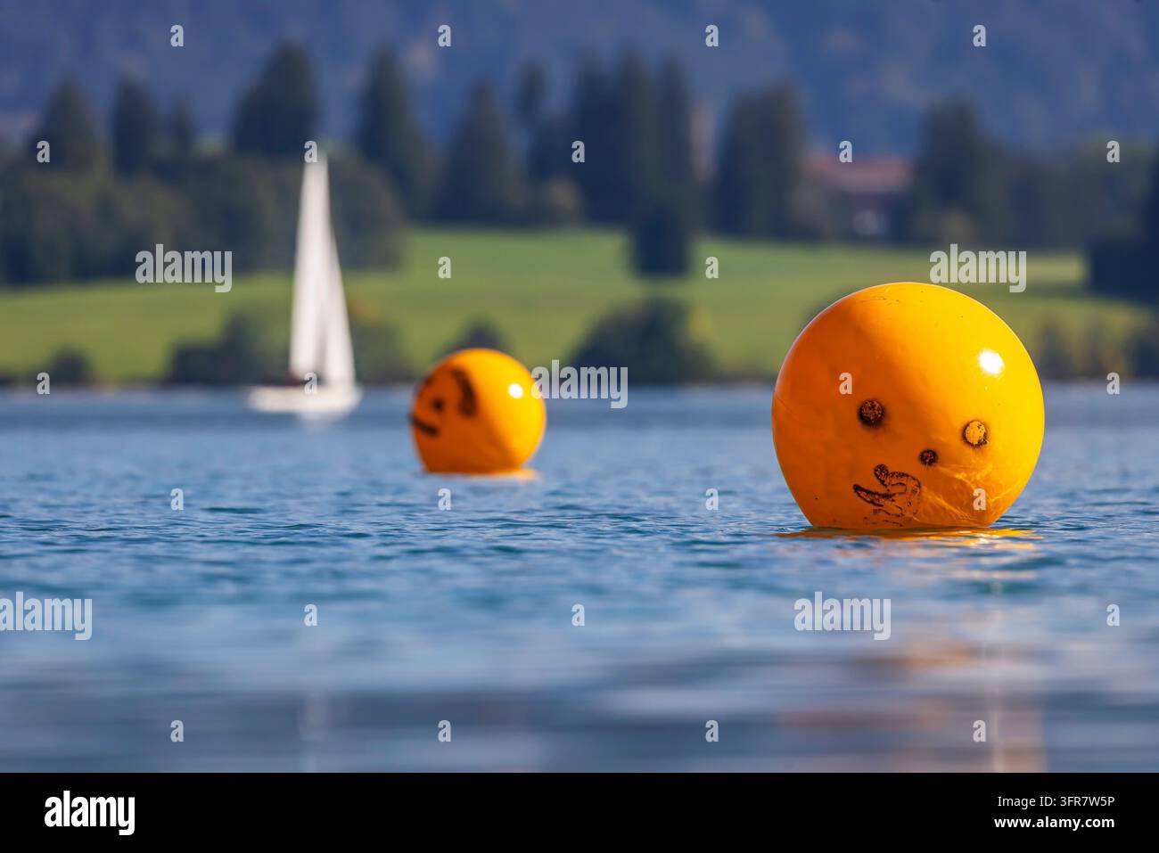Badeplatz Rieden nahe Dietringen am Forggensee. Wenige Wassersportler genießen die letzten warmen Tage an einem sonnigen Herbsttag auf dem See. Orangebojen Stockfoto