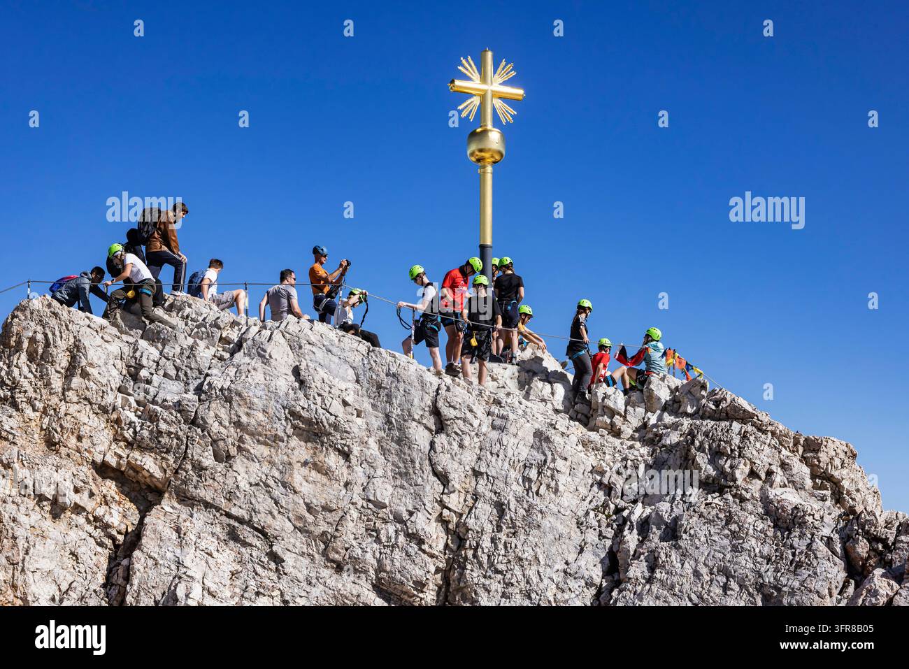 Zugspitze. Starke Menschenmenge am Gipfelkreuz auf dem Ostgipfel. Die Zugspitze ist der höchste Gipfel der Wettersteingeberge und gleichzeitig Germ Stockfoto