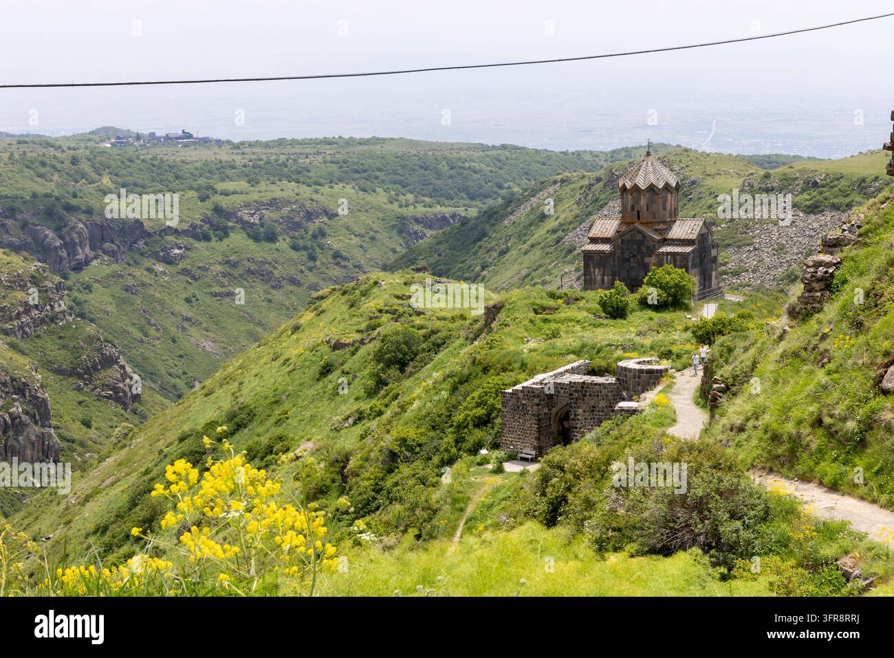Besucher gehen einen Pfad an den zerstörten Mauern der Festung Amberd vorbei in Richtung der Vahramashen-Kirche in den Bergen der Provinz Aragatsotn, Provinz Aragatsotn Stockfoto