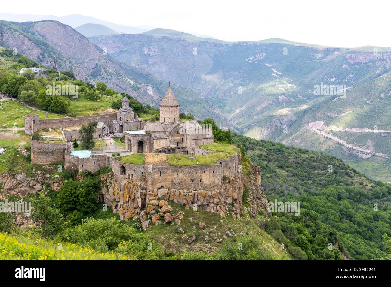 Das Tatev-Kloster und seine Steinmauern mit Blick auf eine tiefe bewaldete Schlucht in den Bergen, Provinz Syunik, Tatev, Armenien Stockfoto