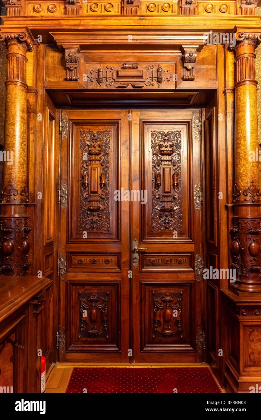Verzierte geschnitzte Holztür im Inneren des Peles-Schlosses in Sinaia, Rumänien Stockfoto