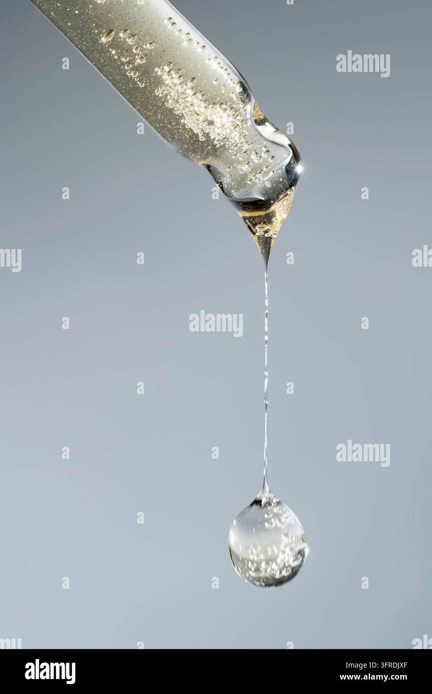 Ein Tropfen Kosmetiköl fällt aus der Pipette. Hautpflegeprodukt Stockfoto