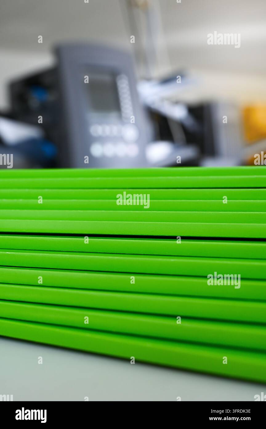 Kleben von Taschenbuchdruck grüner Broschüren in der Buchbinderei oder Druckerei. Druckheftung sortiert. Briefshop oder Buchbinder. Stockfoto