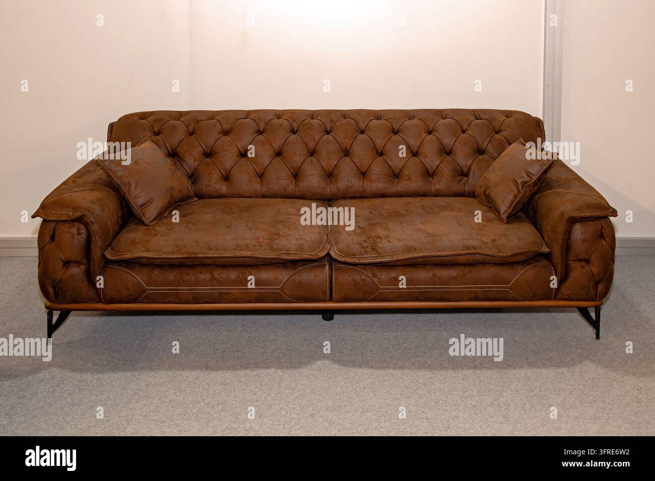 Retro braunes Ledersofa im Chesterfield-Stil als Möbel im Rauminterieur Stockfoto