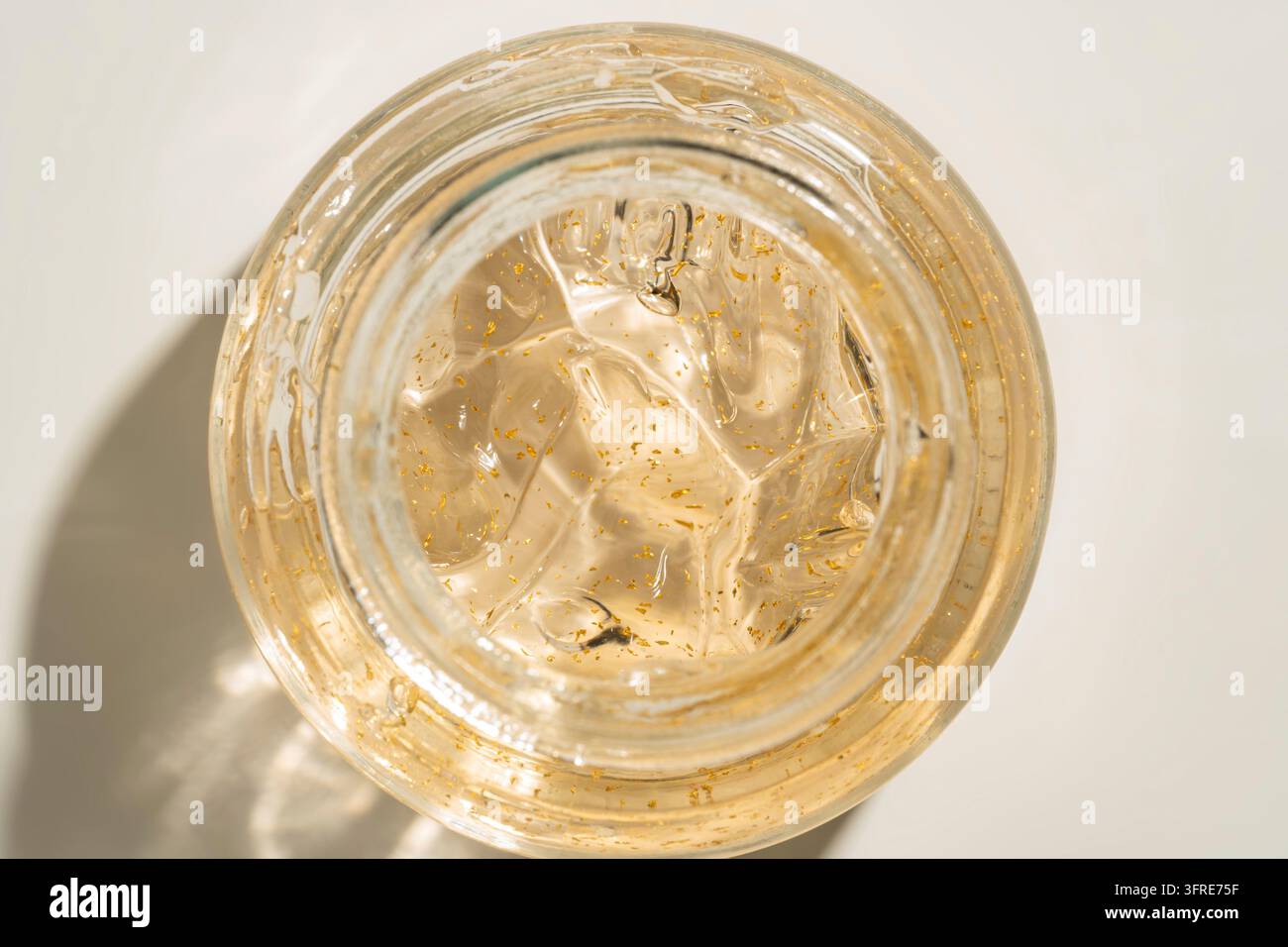 24 Karat Gold Hautpflege Creme Gel in einem Glasgefäß Nahaufnahme. Textur-Makro für Schönheitsbehandlungen Stockfoto