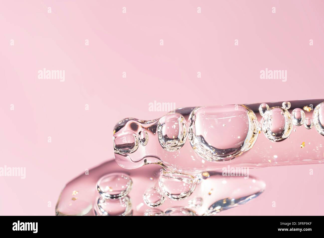 Ein Tropfen kosmetisches Gel oder Gesichtsserumöl fällt von der Pipette. Textur kosmetischer Produkte Stockfoto