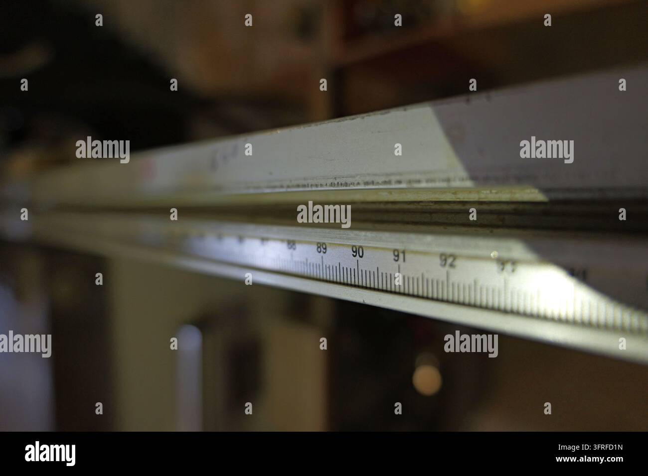 Metalllineal mit Millimetermaßangaben und Zahlen von 89 bis 92, das Präzision und Genauigkeit in Ingenieurwesen, Bau oder Handwerk darstellt Stockfoto