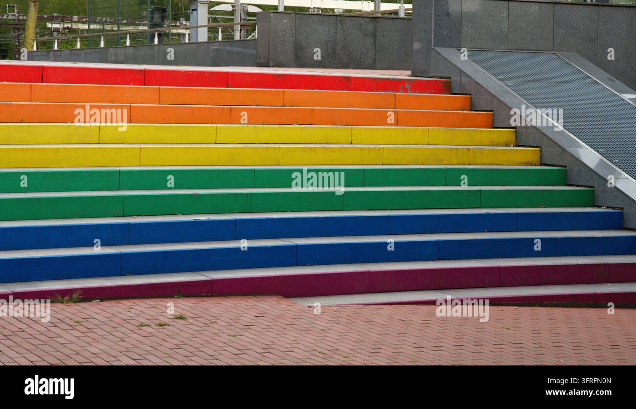 Ein Foto einer breiten Treppe mit hellen Stufen, die in den Farben des Regenbogens gestrichen sind. Hochwertiges Foto Stockfoto