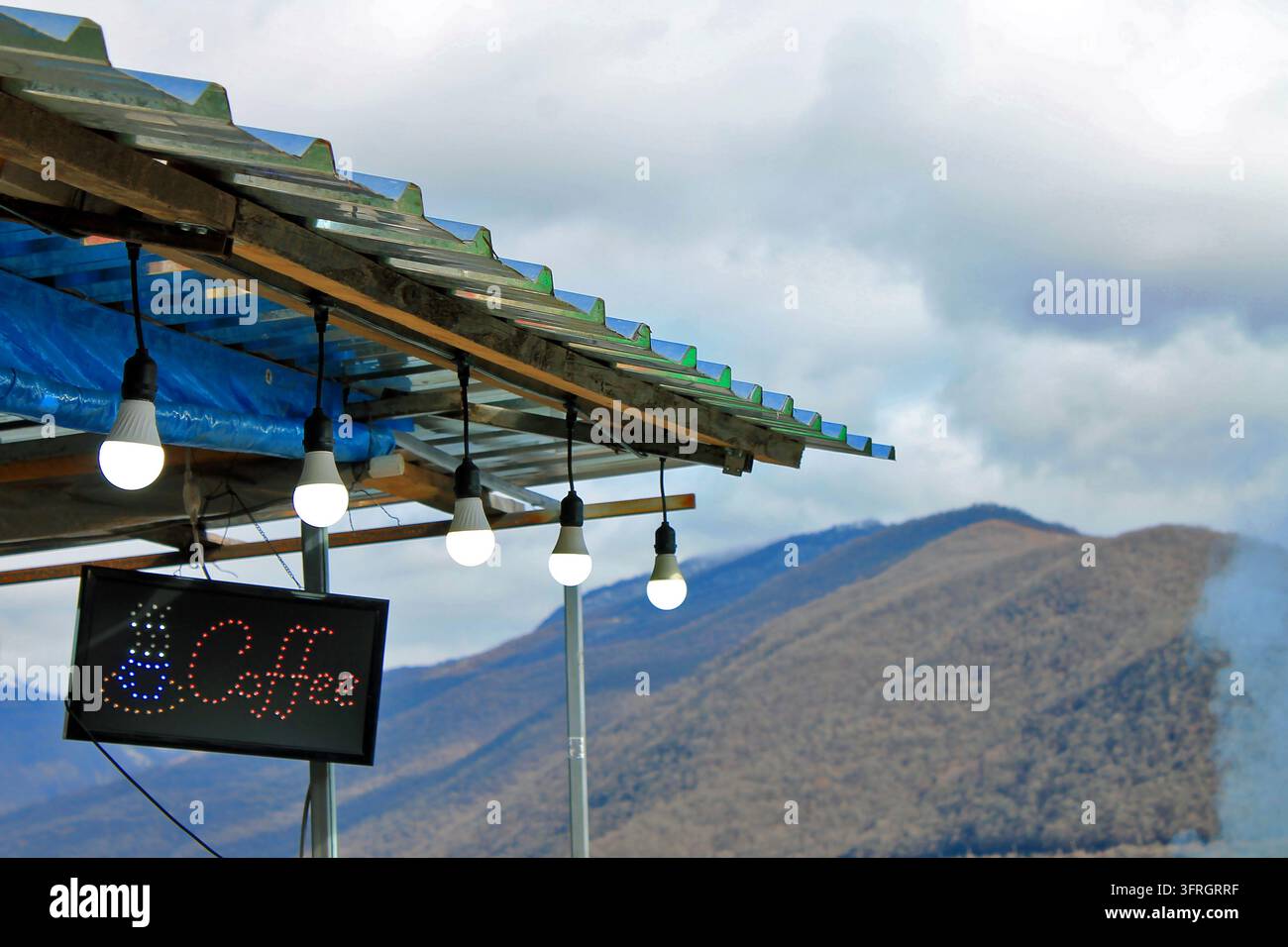 Kaffeeschild auf dem Dach eines lokalen Marktstandes mit Glühbirnen am Straßenrand in der Bergregion von Georgia Stockfoto