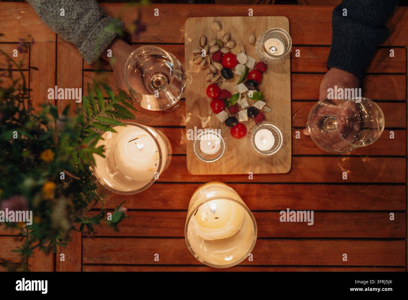 Seniorenpaar genießt ein romantisches Abendessen zusammen auf der Terrasse bei Nacht. Stockfoto