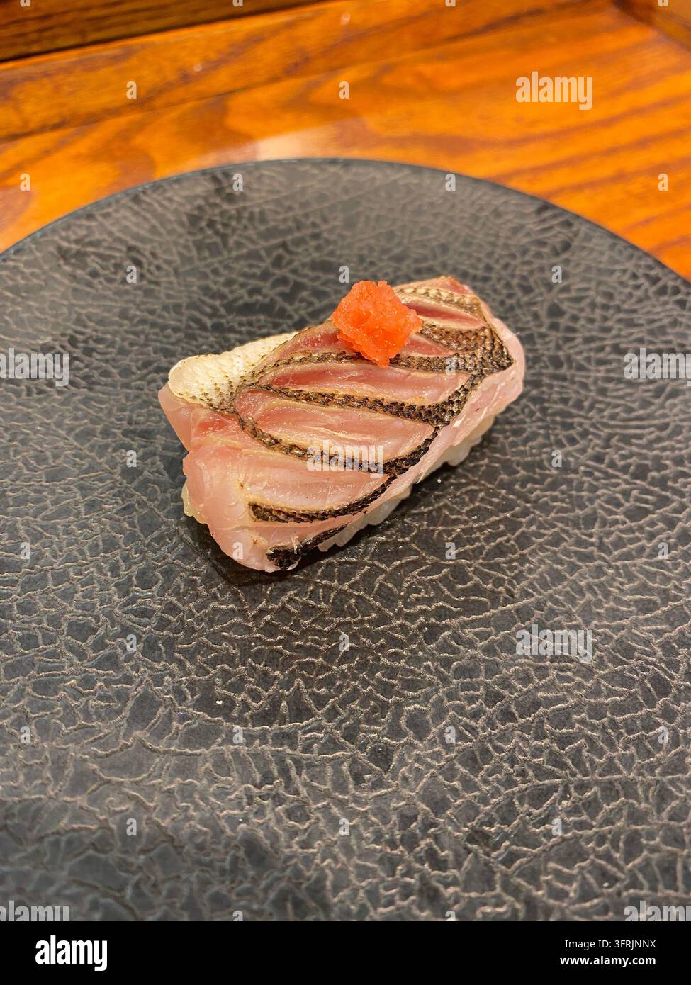 Gebratener japanischer Barrakuda-Nigiri-Sushi, serviert in einem Restaurant in Hakata, Fukuoka, Japan. - Smartphone-aufgenommenes Stockfoto