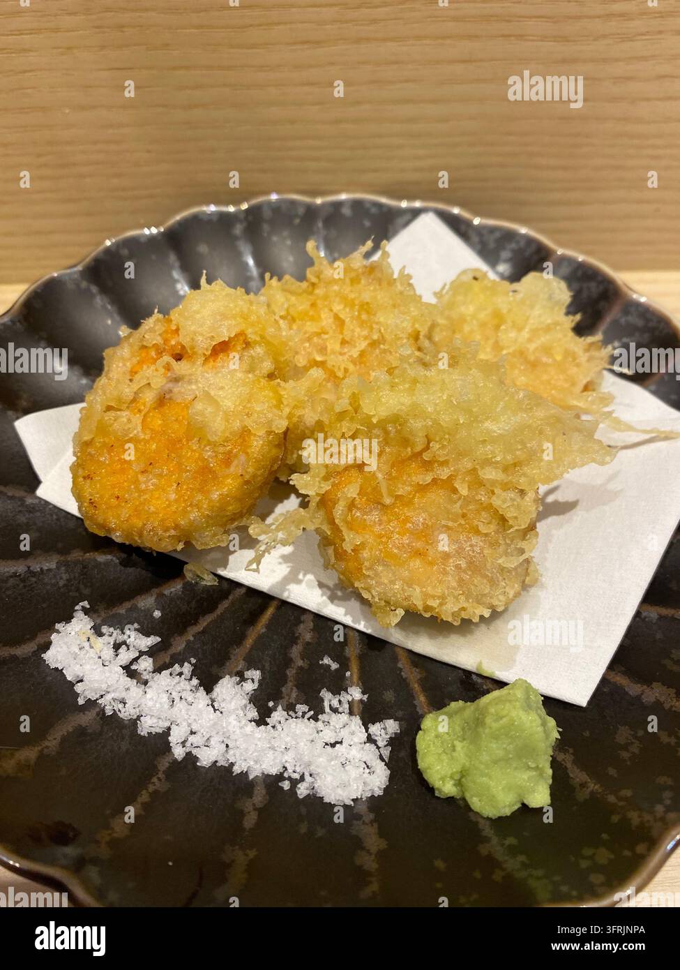 Nahaufnahme von knuspriger gebratener Seezungeleber (Ankimo Tempura), serviert in einem Izakaya-Restaurant in Hakata, Fukuoka, Japan. - Smartphone-aufgenommenes Stockfoto