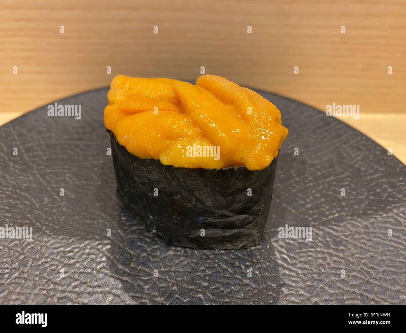 Nahaufnahme von frischem Seeigel (Murasaki Uni) Nigiri-Sushi, serviert in einem Sushi-Restaurant in Fukuoka, Japan. - Smartphone-aufgenommenes Stockfoto