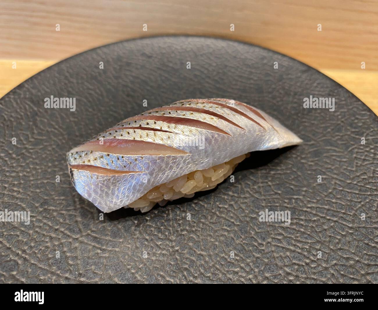 Nahaufnahme von gegartem Kohada-Nigiri-Sushi, serviert in einem Sushi-Restaurant in Fukuoka, Japan - Smartphone-aufgenommenes Stockfoto