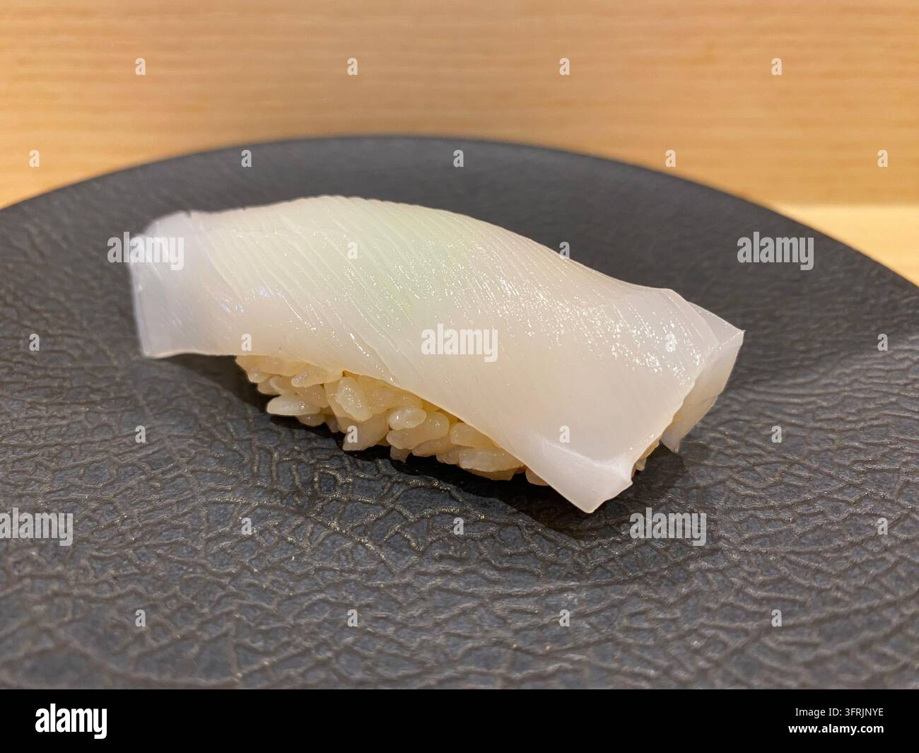Nahaufnahme von frischem Speerseefisch (yari-ika) Nigiri-Sushi, serviert in einem Sushi-Restaurant in Fukuoka, Japan. - Smartphone-aufgenommenes Stockfoto