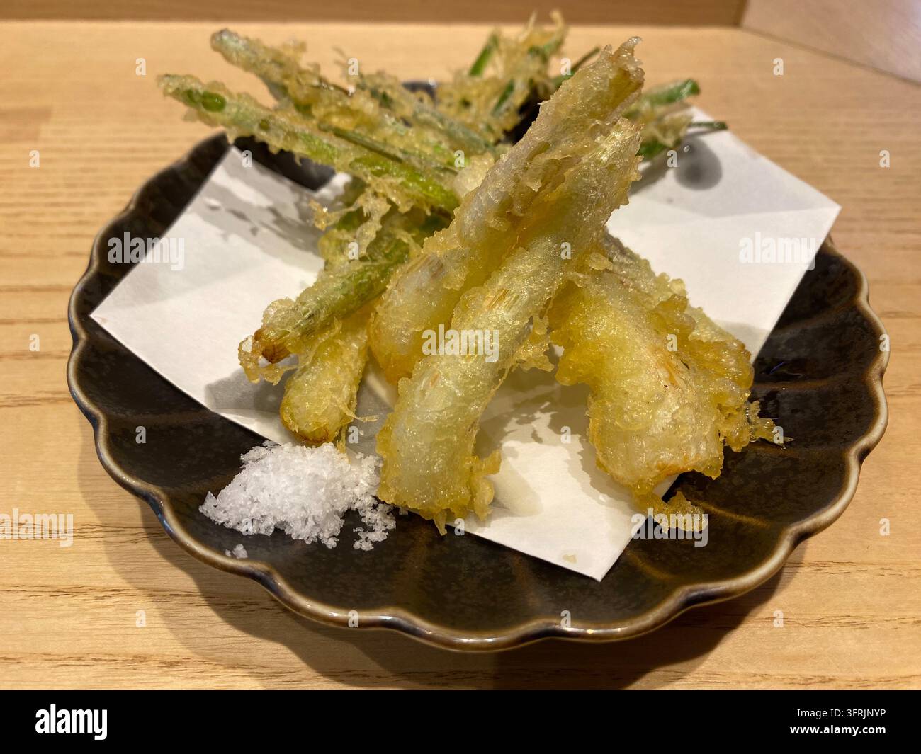 Nahaufnahme von knusprig gebratenen Insel-Schnittlauch (Shima-Rakkyo-Tempura), serviert in einem japanischen Restaurant in Fukuoka, Japan. - Smartphone-aufgenommenes Stockfoto