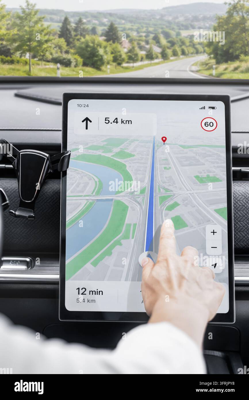 Nahaufnahme eines vertikalen Touchscreen-Displays in einem modernen Autoinnenraum, das Navigationsoberfläche, Routenführung, Reisezeit und Entfernung anzeigt. Automobil Stockfoto