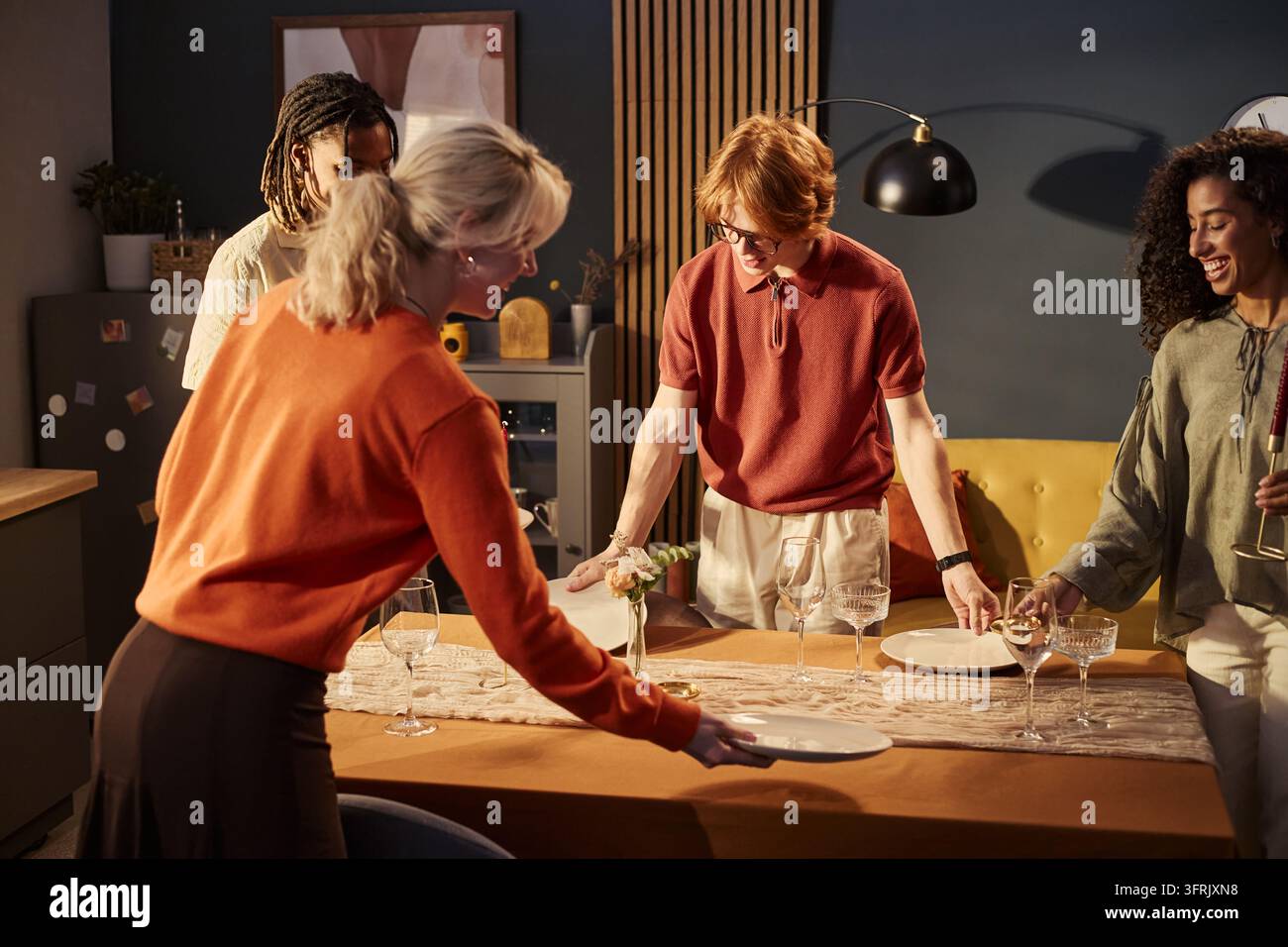 Multikulturelle Freunde bereiten den Esstisch für eine Dinnerparty vor Stockfoto