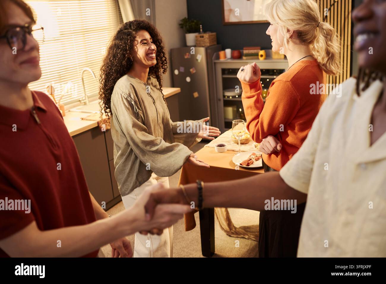 Multikulturelle Gruppe von Freunden, die sich bei einer Hausparty begrüßen Stockfoto