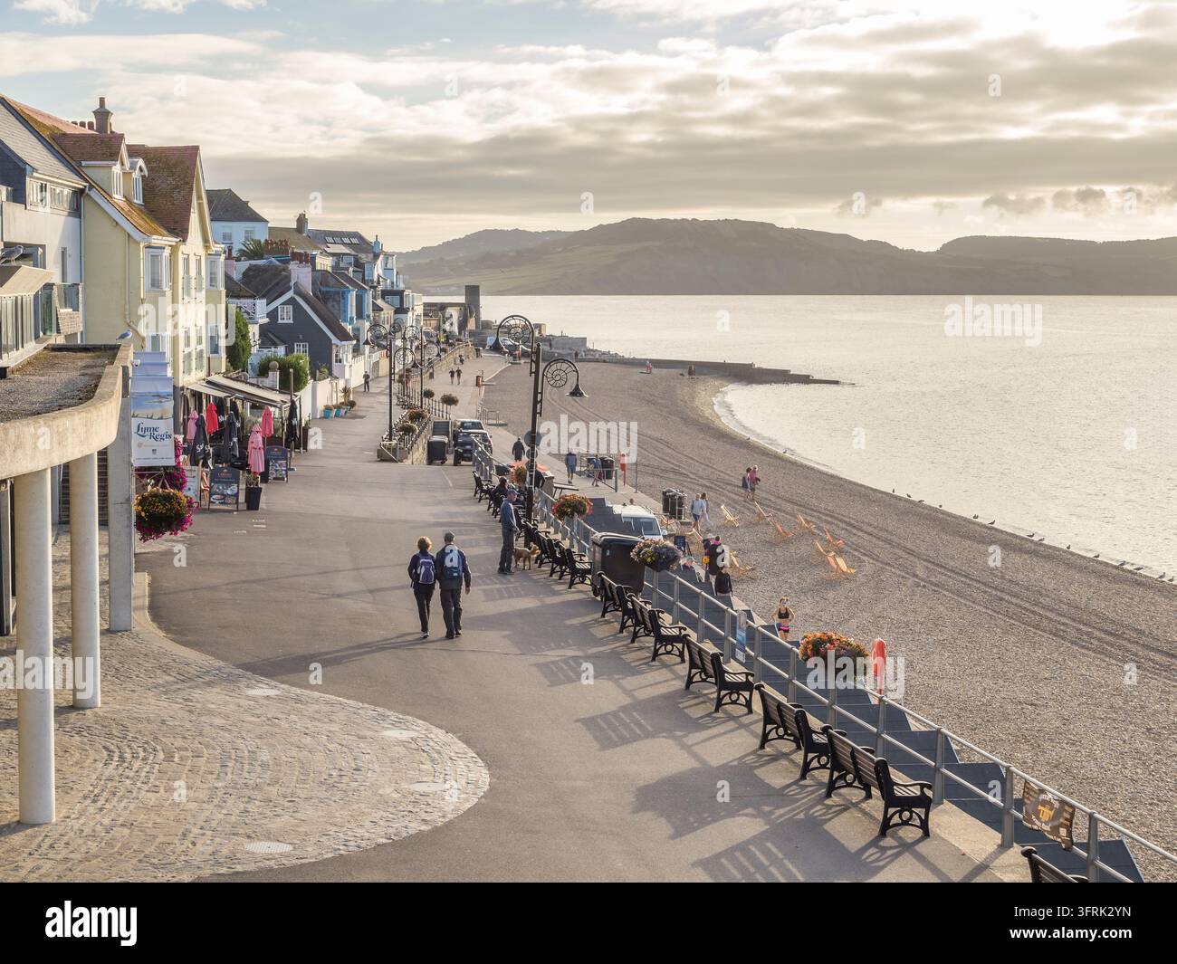 Lyme Regis, Dorset, Paar macht einen frühmorgendlichen Spaziergang am Meer. Lyme Regis ist eine beliebte Küstenstadt an der Südküste, das Herz der Jurassic Coast Stockfoto