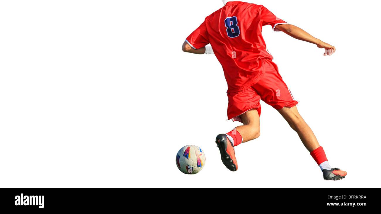 Ein Fußballspieler in roter Uniform tritt den Ball und macht einen Zug. Stockfoto