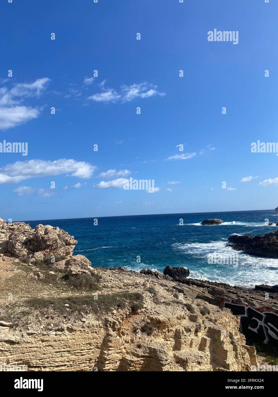 Die wilde Schönheit der felsigen Küste und die endlose Tiefe des Meeres. Wo das tiefe Blau auf die felsige Küste trifft. Allein mit dem Geräusch der Wellen. - Smartphone-aufgenommenes Stockfoto