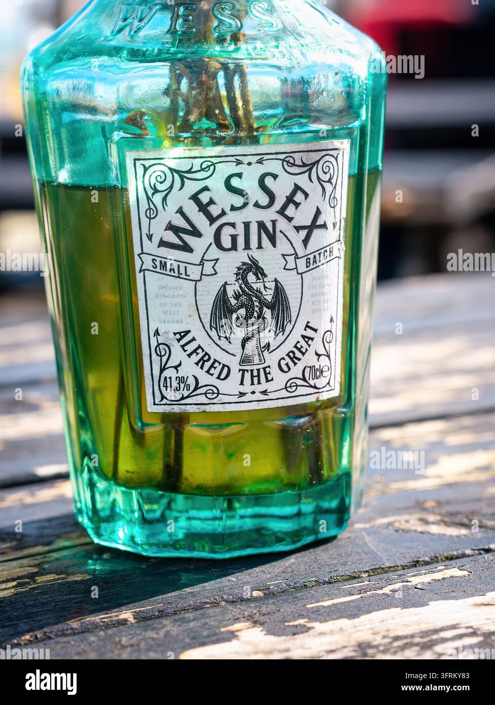 Eine Wessex-Gin-Flasche, die als dekorative Blumendekoration in einem Strandcafé in Pett Level wiederverwendet wurde Stockfoto