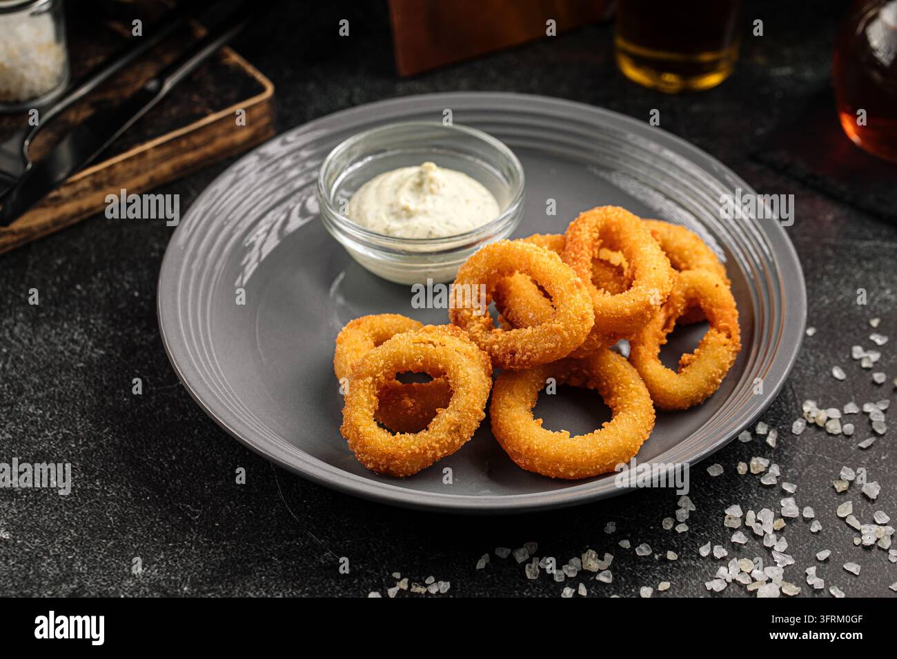 Knusprig gebratene Zwiebelringe mit weißer Sauce Stockfoto