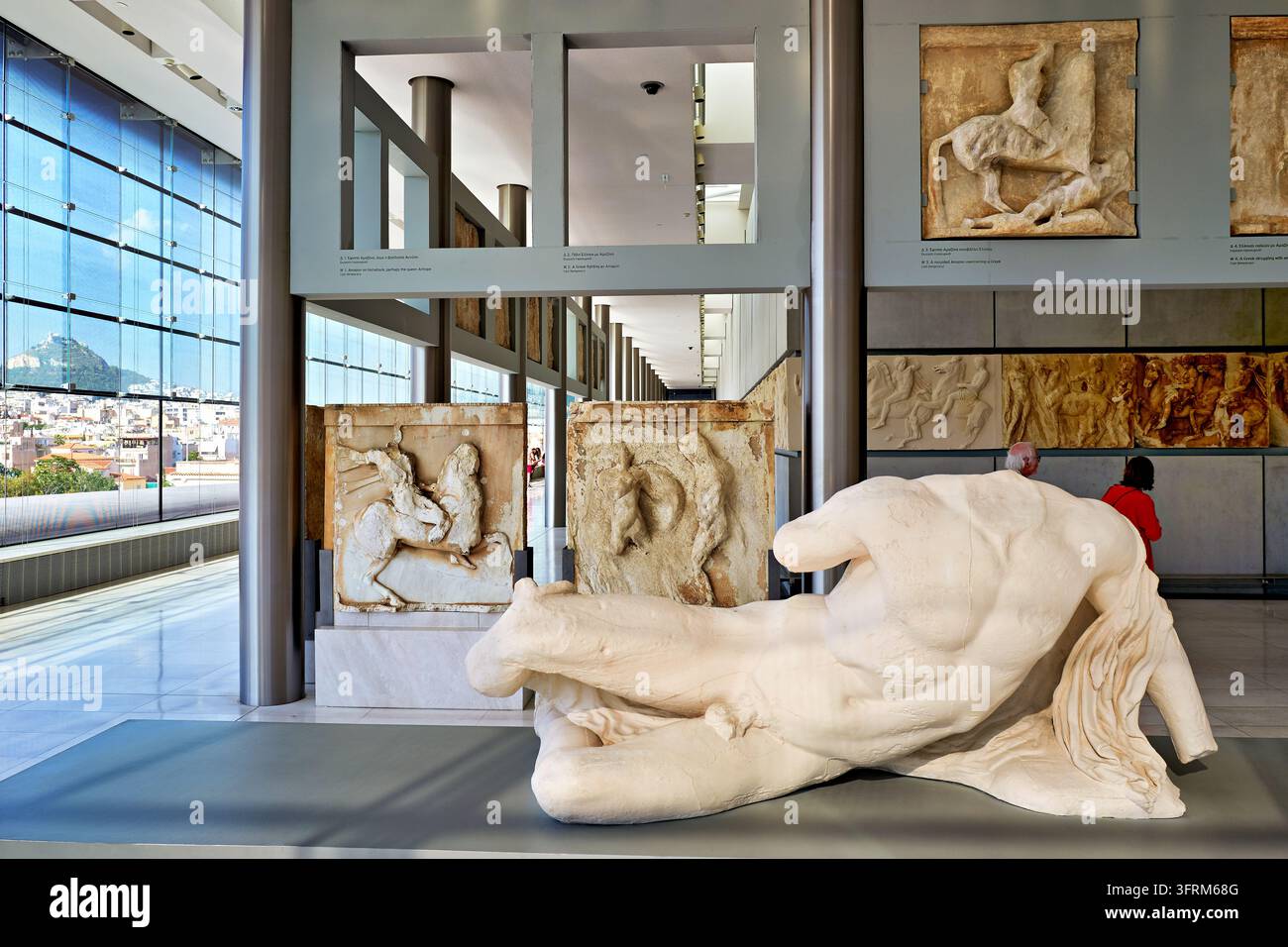 Westmetopen des Parthenon und ein Abguss einer liegenden Giebelfigur in der Galerie der obersten Etage, mit dem Berg Lykabettus, der durch die Glasfassade sichtbar ist Stockfoto