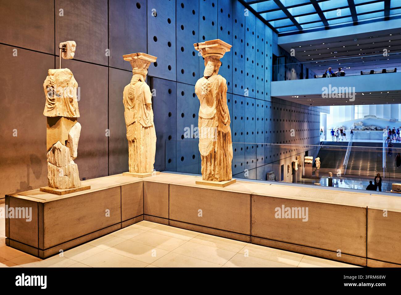 Rückansicht originaler Marmormädchen aus dem 5. Jahrhundert v. Chr. von der Akropolis, gezeigt in einer modernen Beton- und Glasgalerie in Griechenland, mit Besuchern unten. Stockfoto