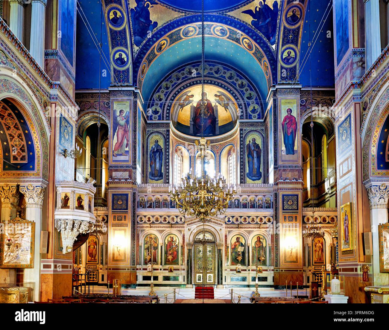 Innenraum einer griechisch-orthodoxen Kirche mit Fresko der Jungfrau und des Kindes im Apsisfresko, vergoldetem Kronleuchter und Marmor-Ikonostasen in der Mitropolis, Athen, Griechenland. Stockfoto