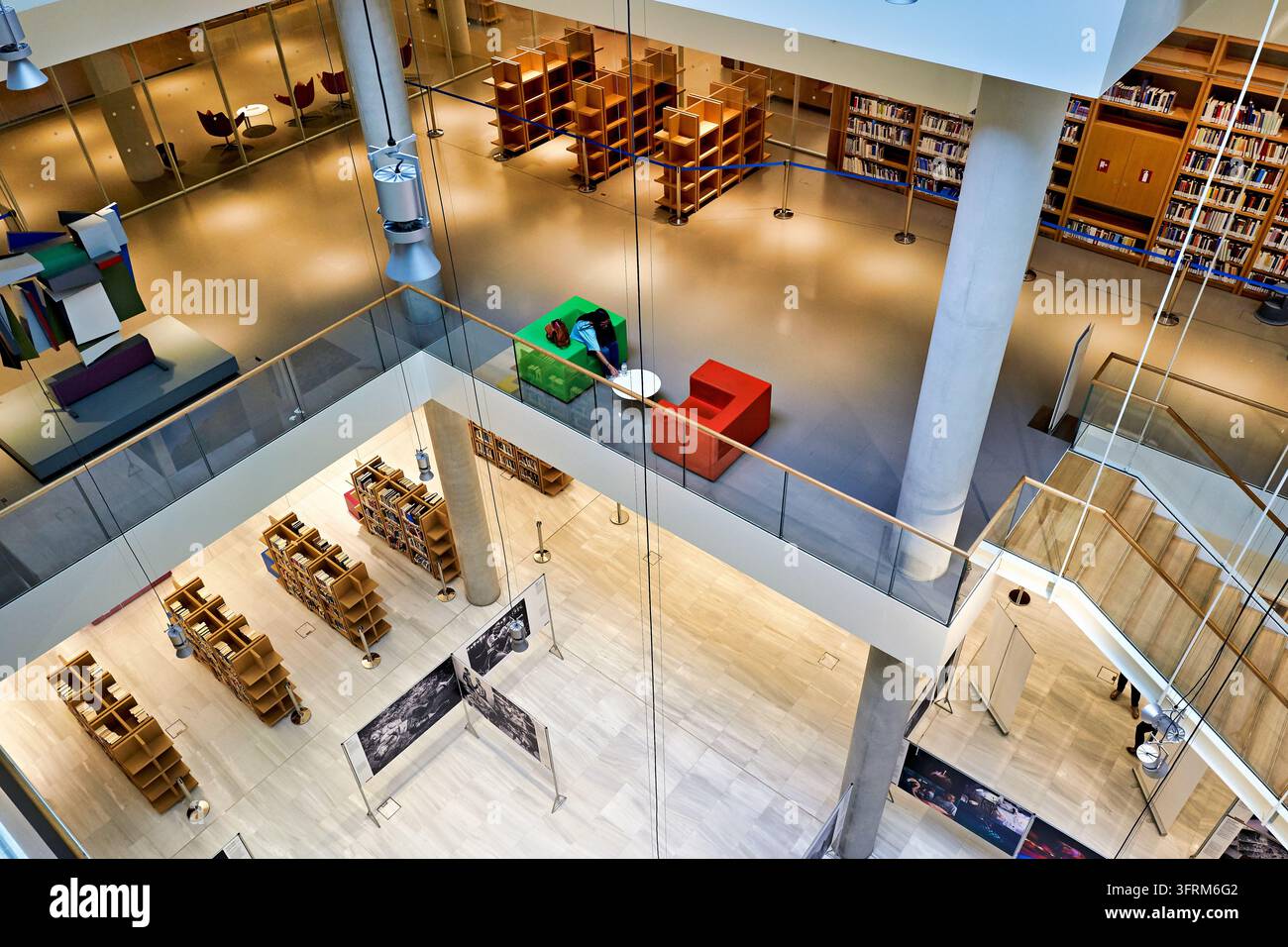 Hochwinkelansicht von offenen Bücherregalen, Lesebereichen und einer Fotoausstellung im Kulturzentrum der Stavros Niarchos Stiftung, Griechenland Stockfoto
