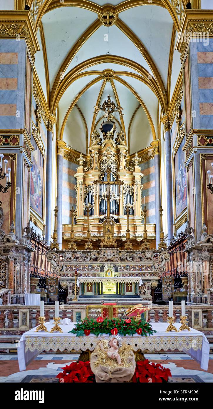Polychromer Marmor-Barock-Sanktuarium, vergoldete Pfeifenorgel und gotische Kreuzrippengewölbe mit einer Jesuskind-Figur und Weihnachtssternen in Kampanien, Italien Stockfoto