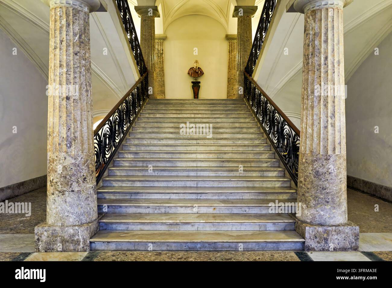 Marmorstufen mit schmiedeeisernen Balustraden führen zu einem klassischen Büsten auf dem Treppenabsatz eines historischen Gebäudes in Neapel, Italien Stockfoto