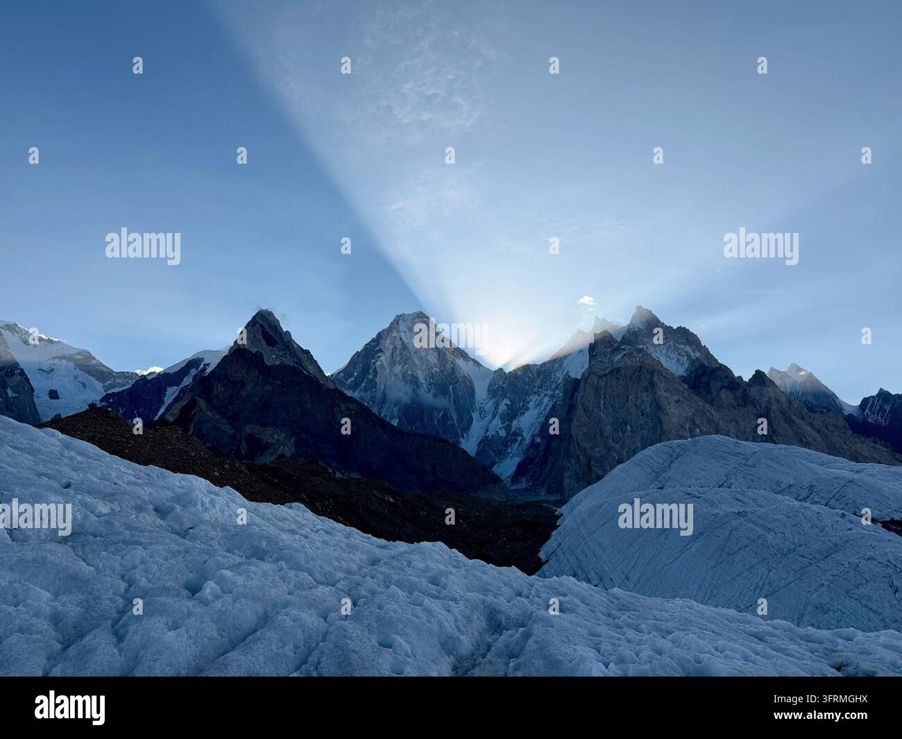 Panoramablick auf die schnee- und eisbedeckte Karakorum-Bergkette mit spaltenmusterndem Gletschereis im Vordergrund, nahe Concordia. Stockfoto