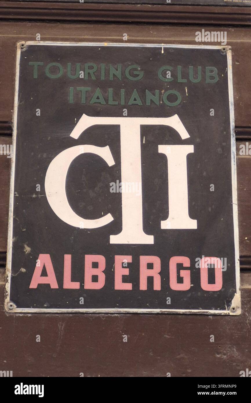 Vintage Touring Club Italiano TCI Albergo Metallschild auf Holzoberfläche, italienische Hotel-Empfehlungsplakette mit klassischem Monogramm - Smartphone-aufgenommenes Stockfoto