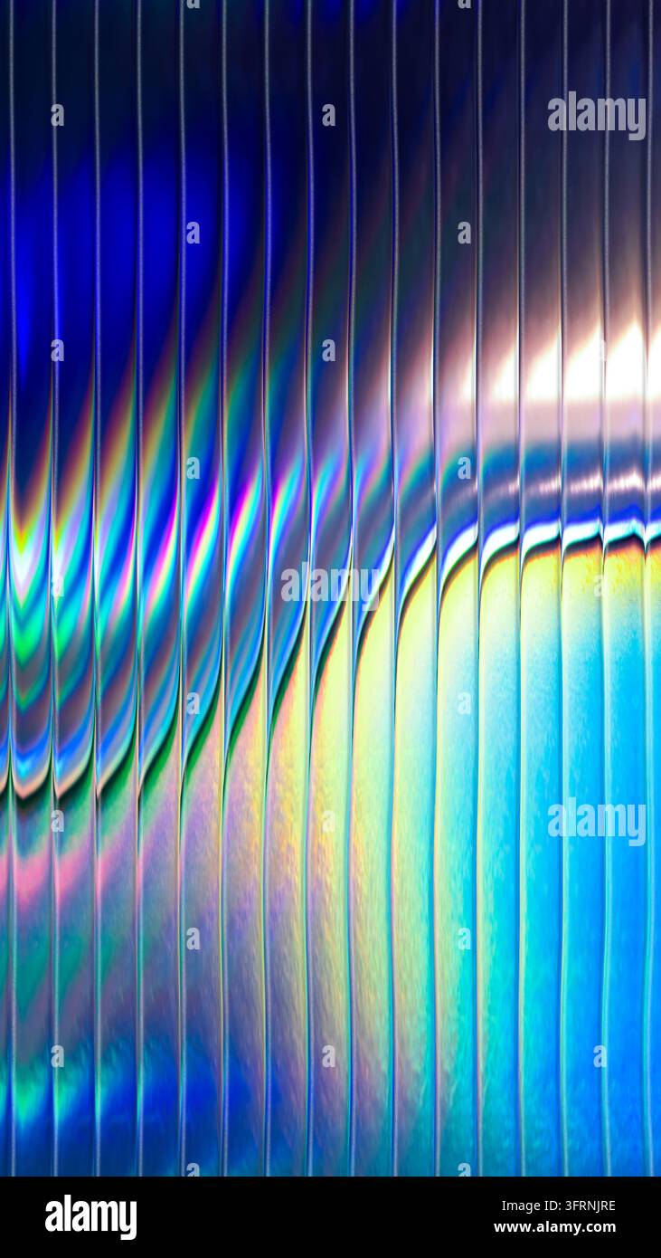 Abstrakter Nahaufnahme von irisierendem Prismenlicht, das durch strukturiertes Glas reflektiert wird und lebendige blaue, zyanfarbene, gelbe und rosafarbene Spektralbänder mit leuchtendem Charakter erzeugt Stockfoto