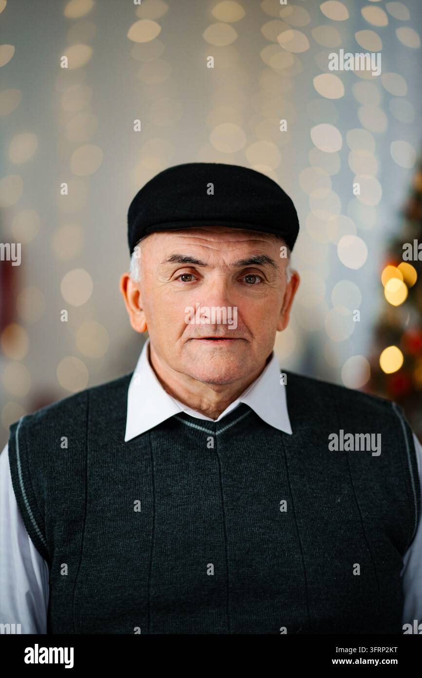Senior Mann mit flacher Kappe schaut in die Kamera Stockfoto