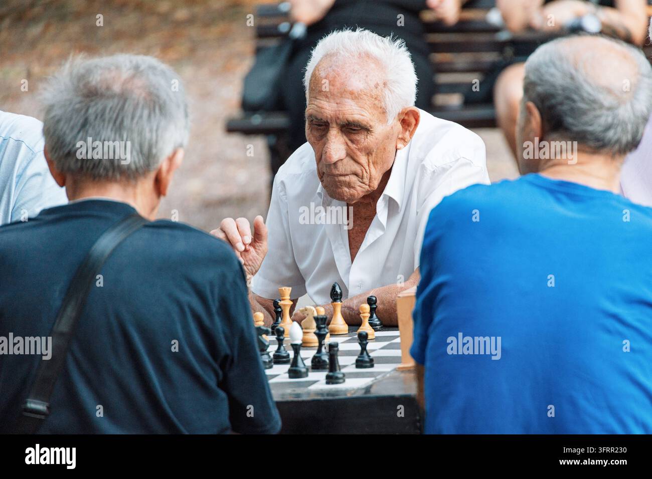 8. August 2026, Belgrad, Serbien: Ältere Männer konzentrieren sich auf ein strategisches Schachspiel im Freien, genießen den Ruhestand und mentale Aktivität Stockfoto