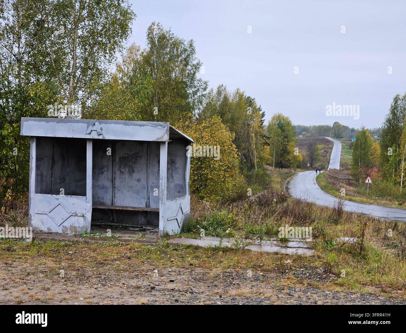 Kleine, baufällige Bushaltestellenhütte mit einem Schild an der Seite. Stockfoto