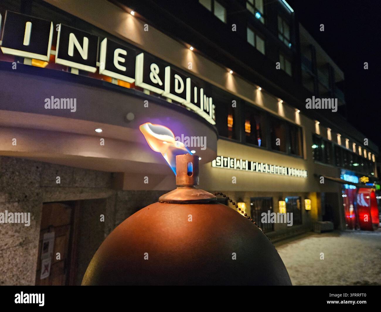 SOELDEN - 13. JAN 2025: Ein großes Gebäude mit einem Schild, auf dem steht Line and Dine. Ein großer Ball mit einer Flamme darauf steht vor dem Gebäude Stockfoto