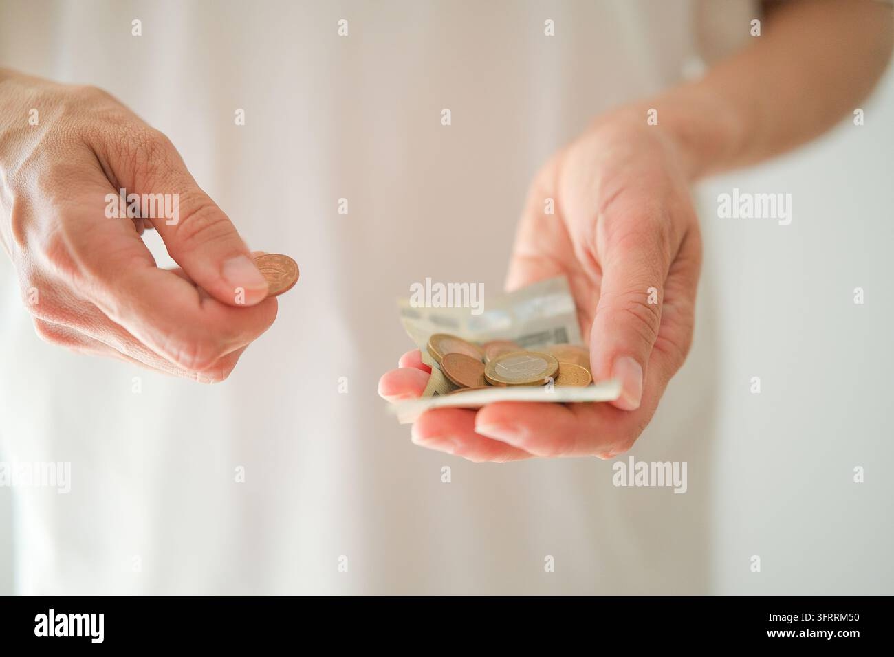Frauenz Hände zählen Euro-Münzen und Kleinbetrags-Euro-Banknoten, Konzept von finanzieller Notlage, Schulden und Arbeitslosigkeit, Haushaltsbudgetierung mit Stockfoto