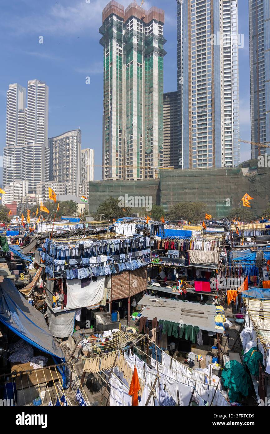 Vertikale Ansicht der Dhobi Ghat-Waschhütten und Wäscheleinen, die von neuen Wolkenkratzern und im Bau befindlichen Türmen überragt werden, Maharashtra, Mumbai, Indien Stockfoto