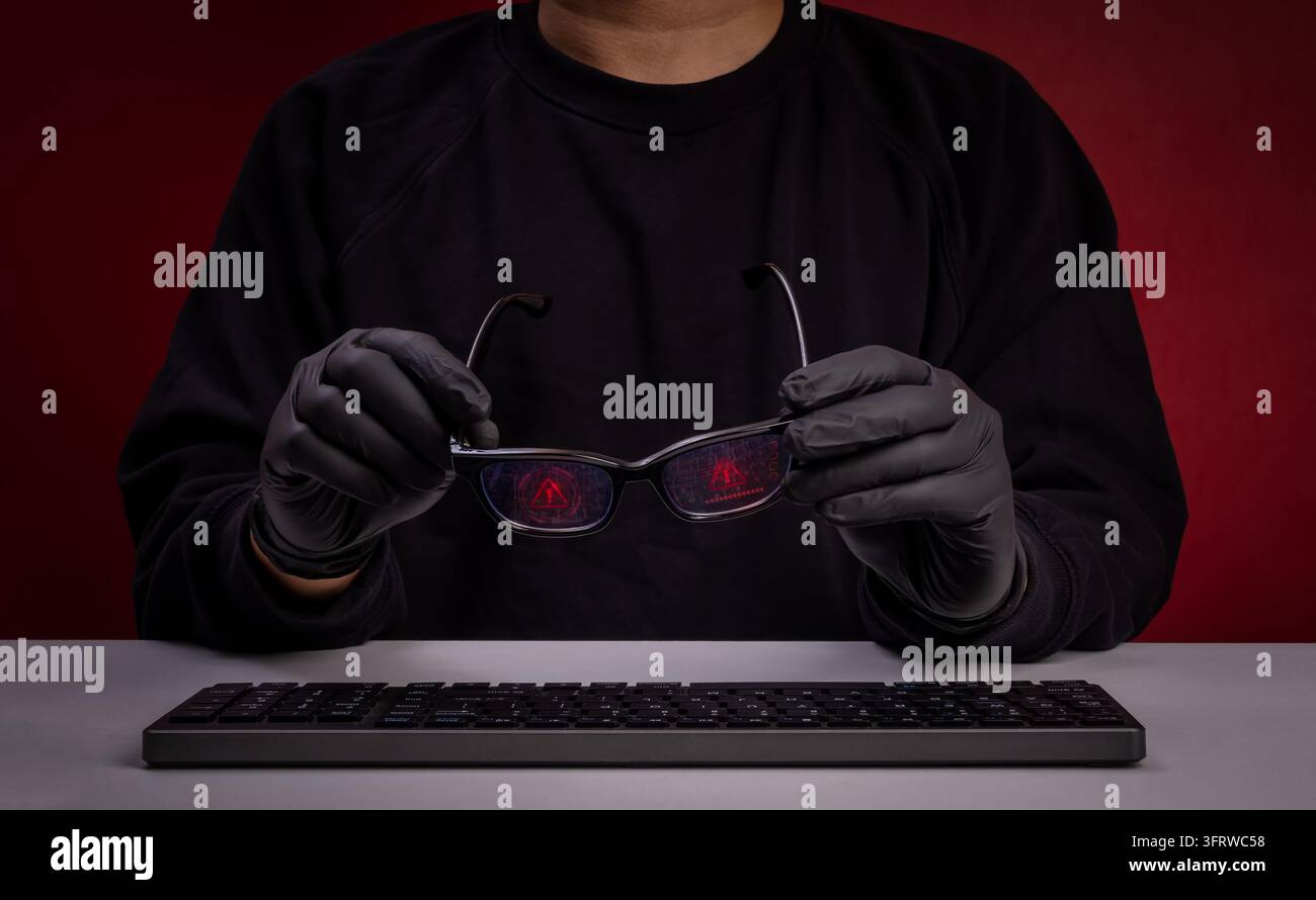 Anonymer Betrüger oder Hacker hält Smart-Glasses mit Warnschnittstellen über der Tastatur. Social Engineering-Betrug, digitale Identitätsverschleierung, Cyberkriminalität Stockfoto