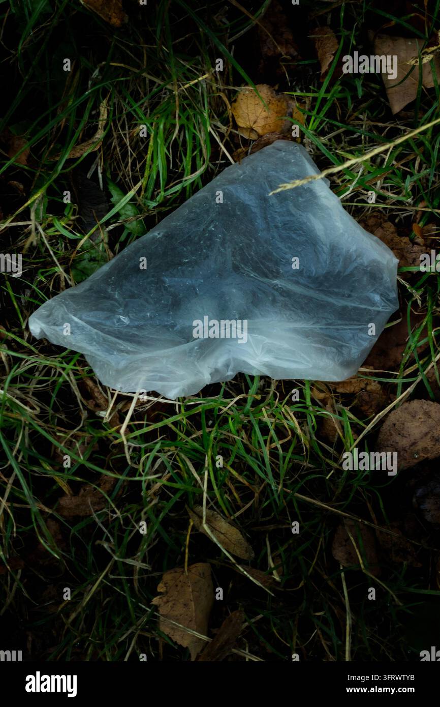 Eine zerknitterte durchsichtige Plastiktüte mit einer darin eingewickelten Pistole Stockfoto